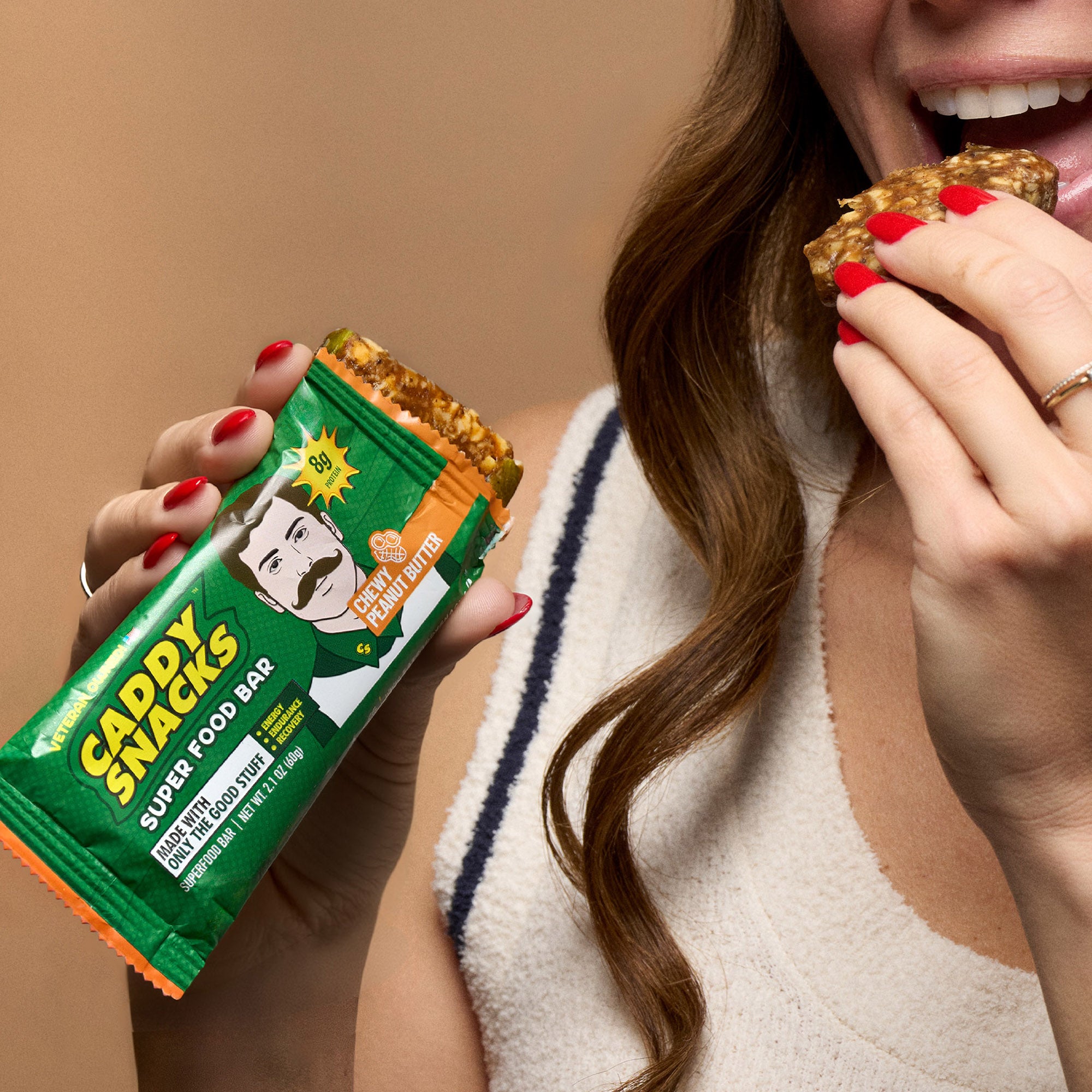 Chewy peanut butter snack bar in hand near mouth
