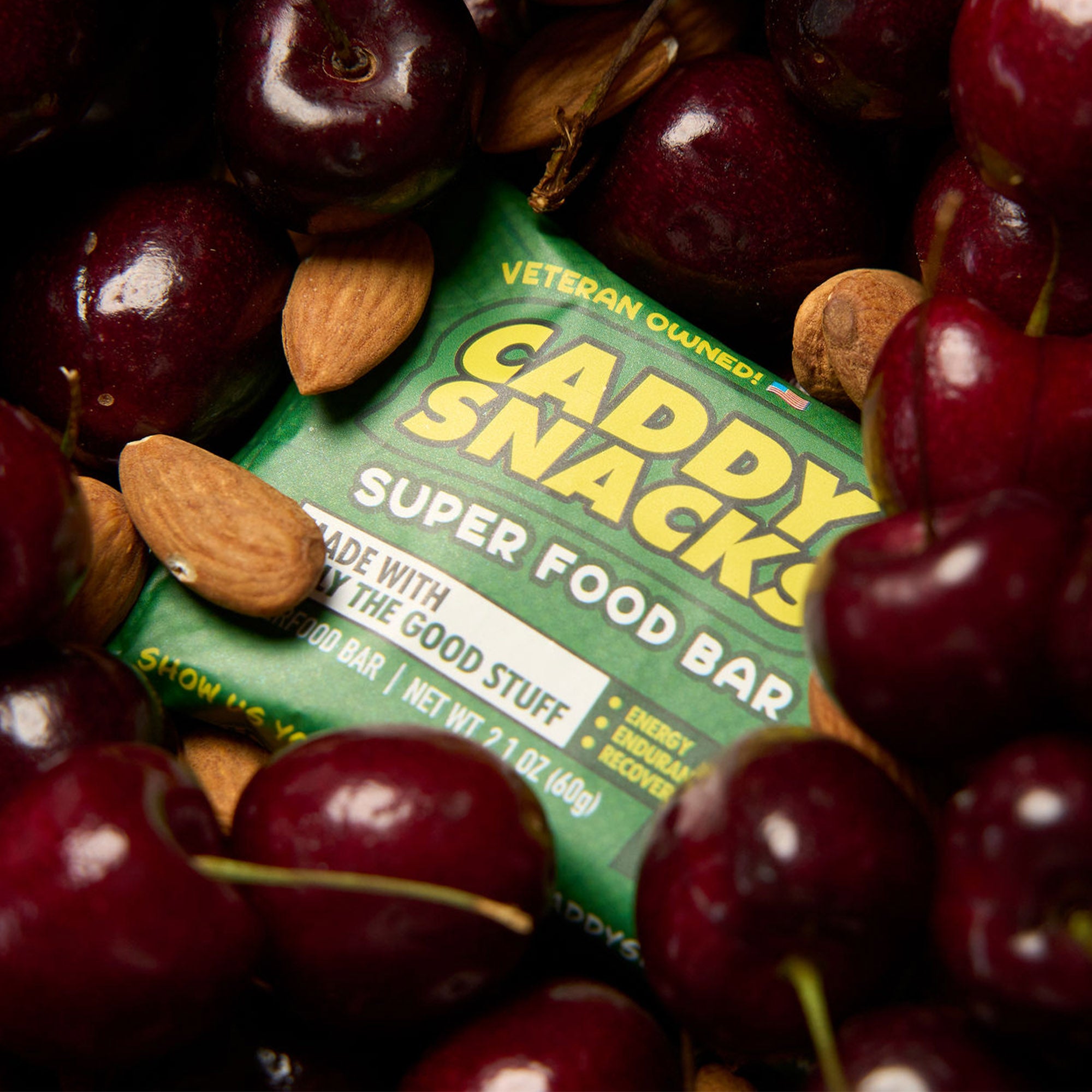 Close-up of green super food bar package among cherries and almonds