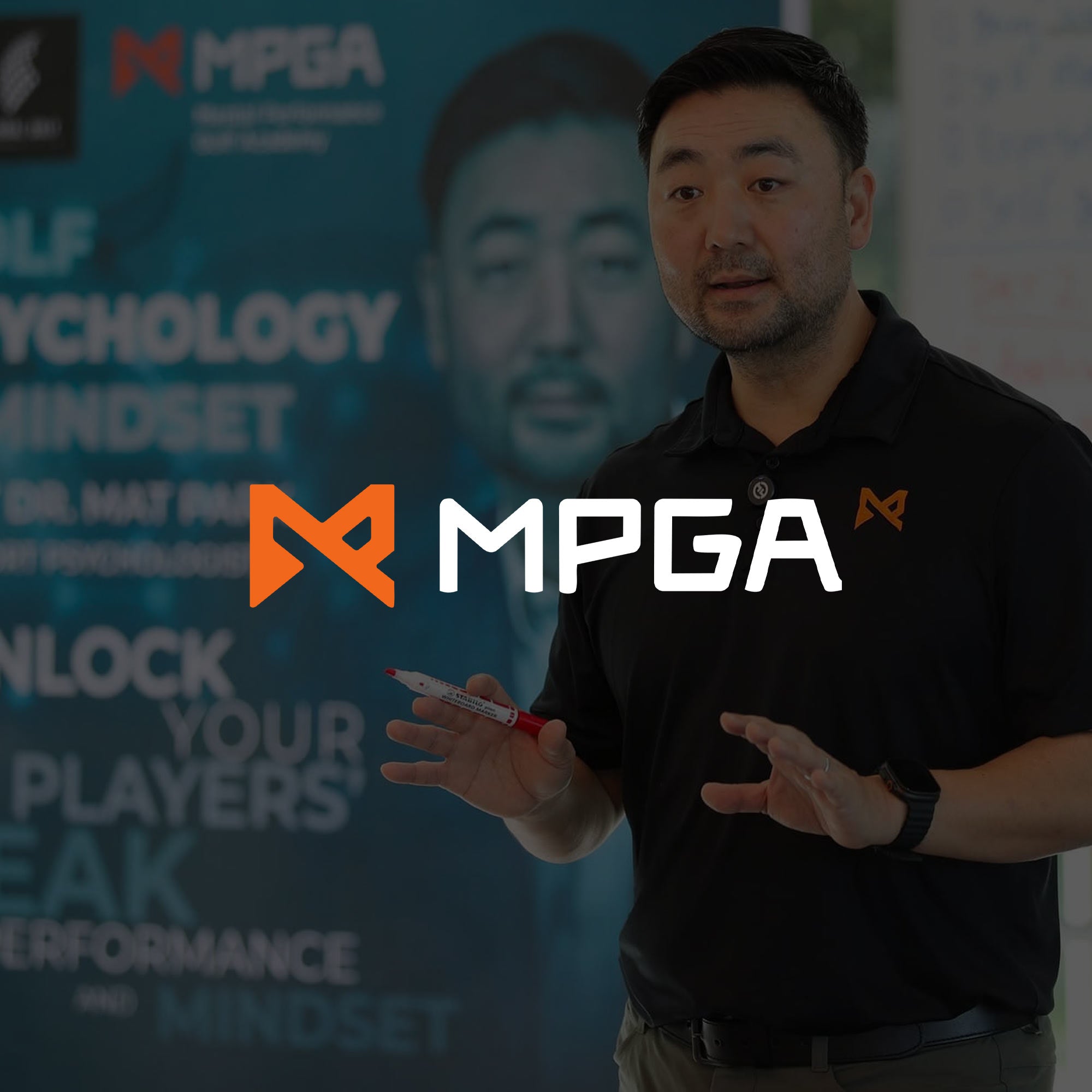 Man speaking in front of an MPGA branded background